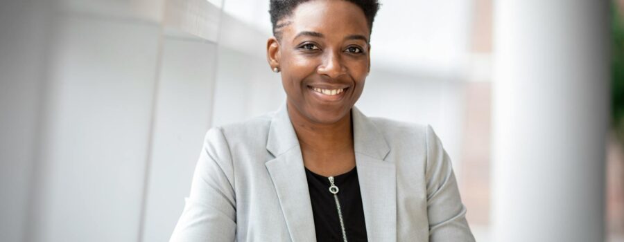 Confident African American businesswoman smiling inside a modern office space.